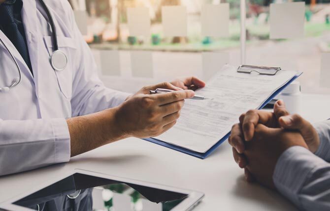 Two individuals going over a clinical consultation form.